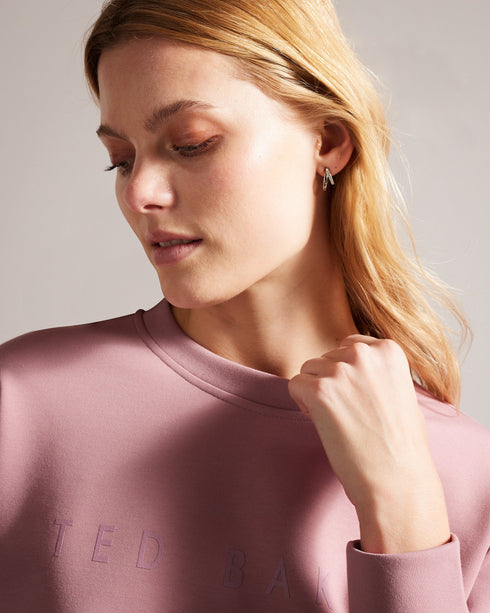 LIVANAA-Tops-Who says you can't be comfortable and chic? With a crew neck, long sleeves and embossed logo detail, LIVANAA is the staple sweatshirt that your wardrobe has been craving. Sweatshirt Embossed Ted Baker logo Crew neck Long sleeves Ayo is 5'8" / 1.73m and wears Red in a Ted size 1- Ted Baker Romania